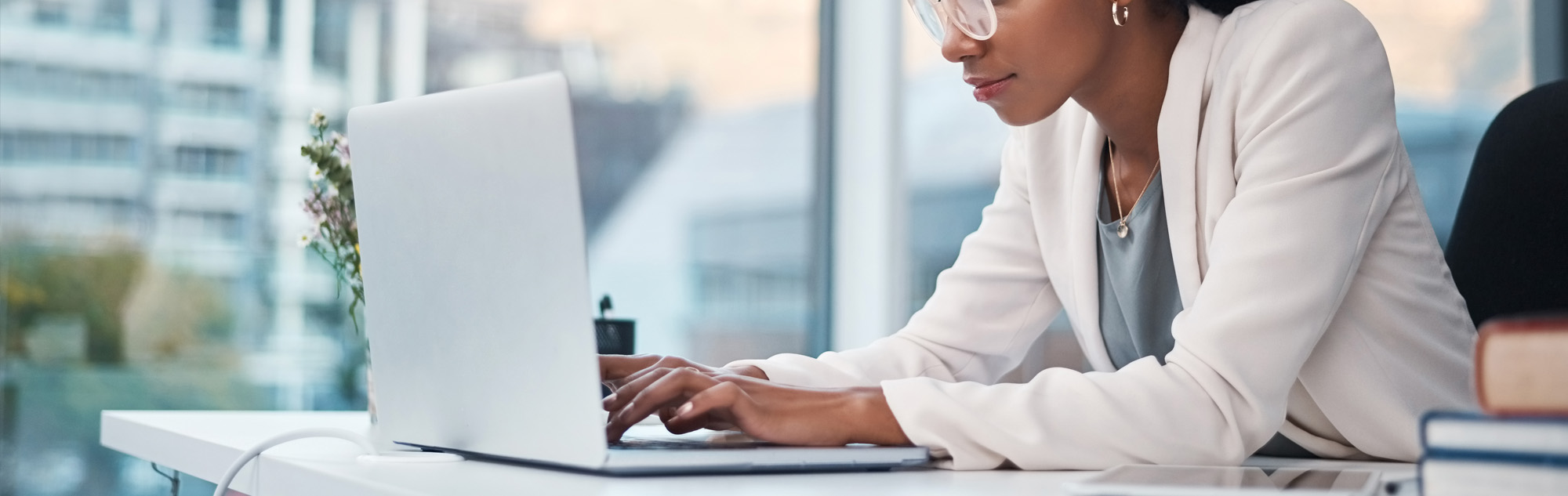 Woman works on computer in office.