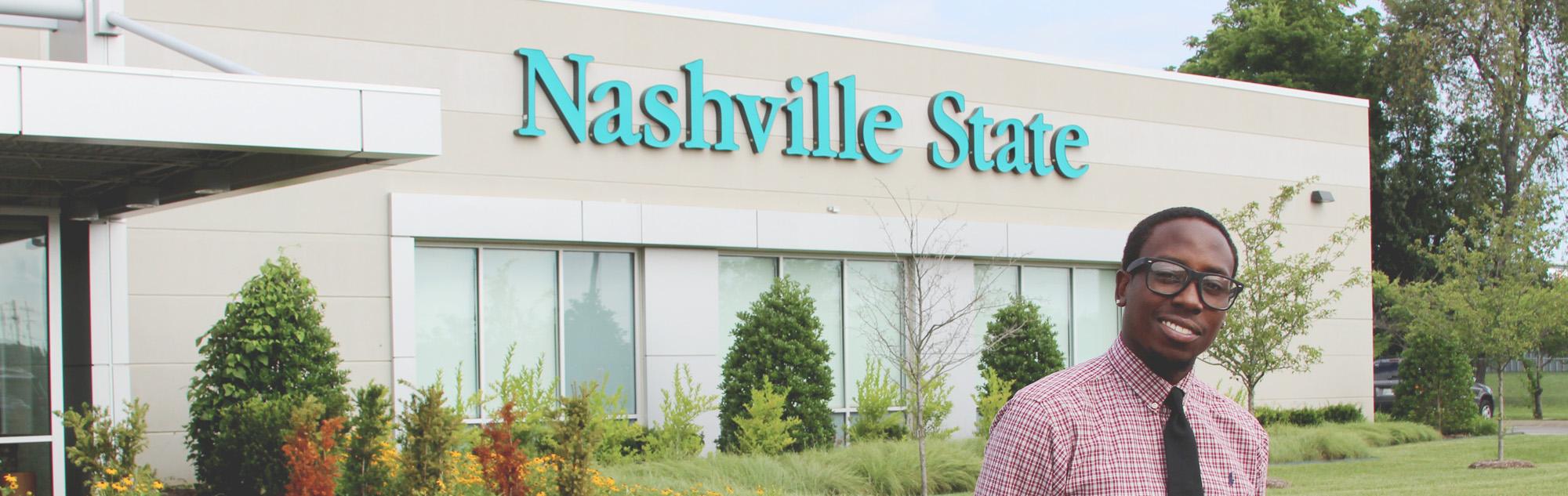 Student stands in front of main building on the Clarksville campus.