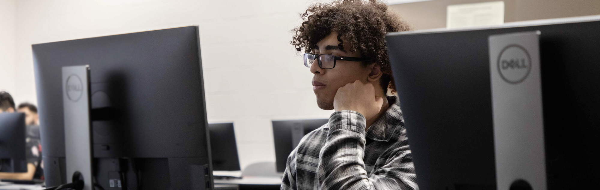 Computer student looks at Dell computer screen.