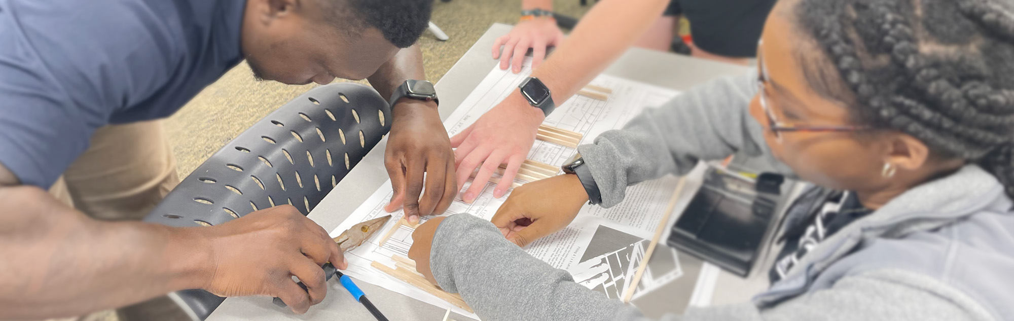 Three students work on class assignment.