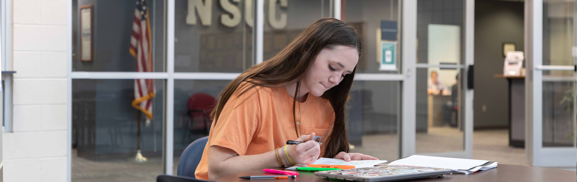 Student studies in Humphreys campus lobby.