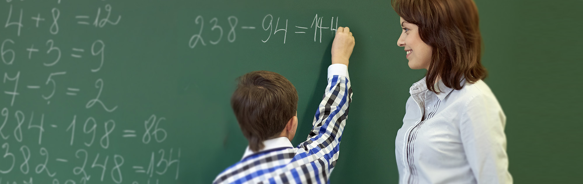 Teacher assists student with math equations.