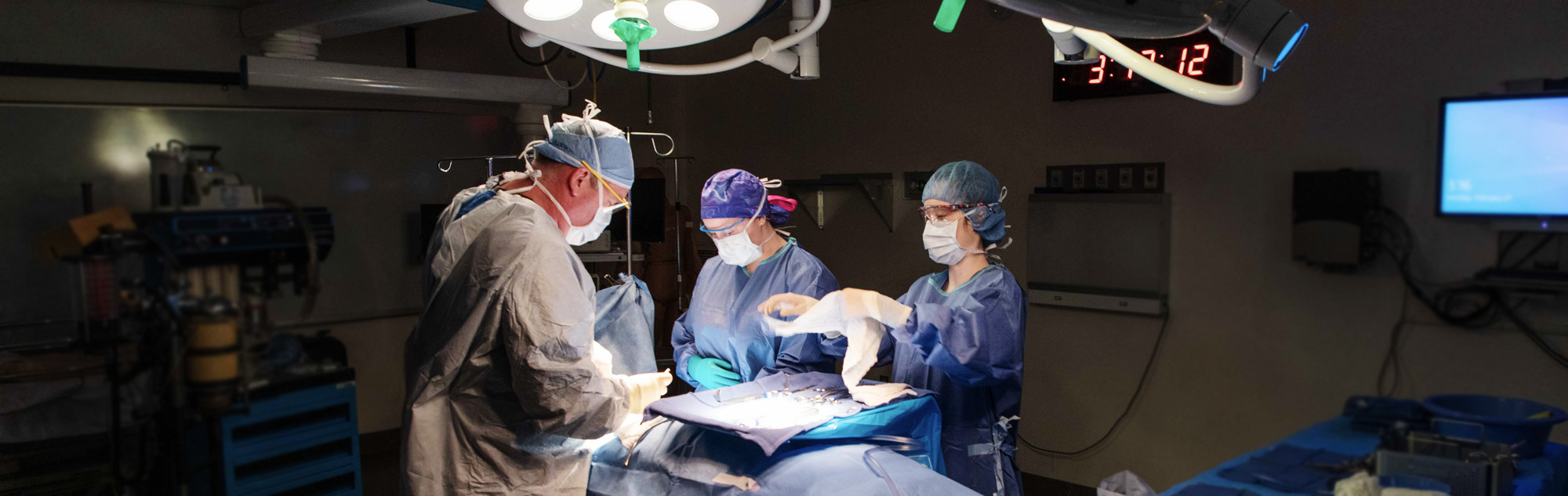 Surgical technology students and faculty work in operating room lab.