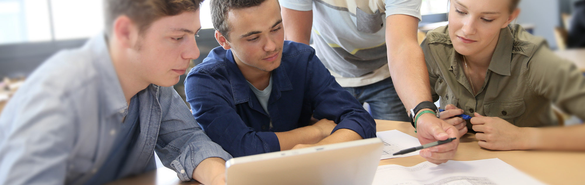 Three students looking at plans.